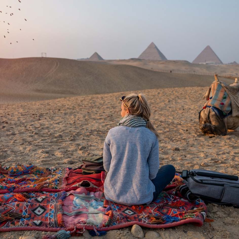 femme dans le désert avec des pyramides