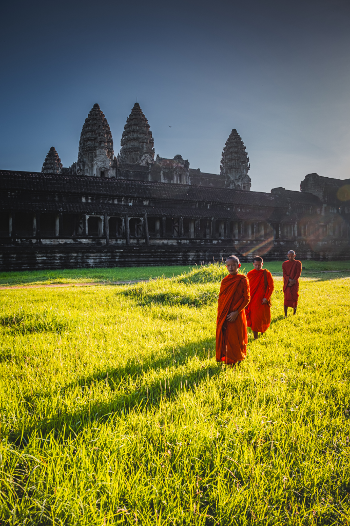 Des moines bouddhistes marchent sur l’herbe à Angkor Wat, Siem Reap, Cambodge